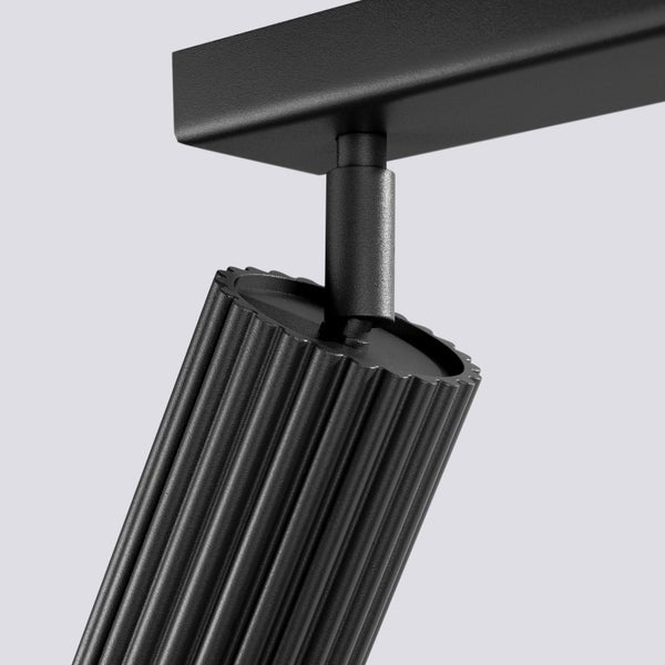 Schwarze Deckenleuchte mit geripptem Lampenkopf.