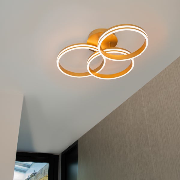 Goldfarbene Deckenleuchte mit vier LED Ringen an der Decke