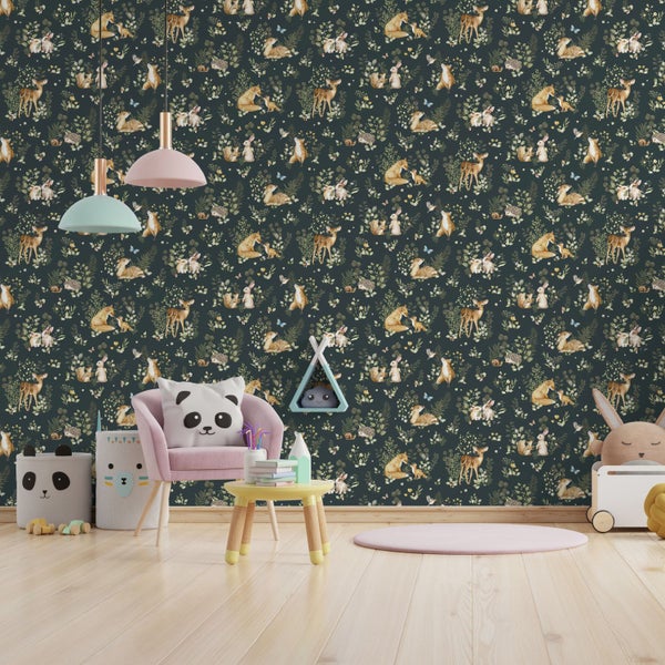 Kinderzimmer mit dunkelgrüner Waldtier-Vliestapete, rosa Sessel, kleinem runden Tisch und verspielten Accessoires auf hellem Holzboden.