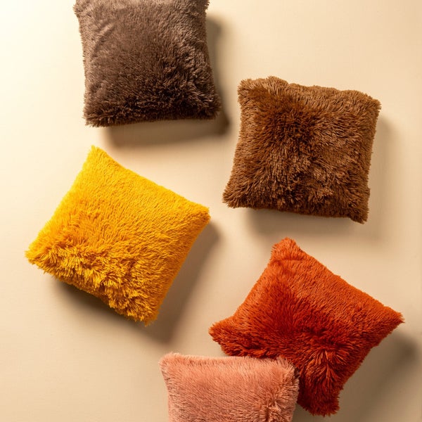 Mehrere flauschige Dekokissen in verschiedenen Farbtönen