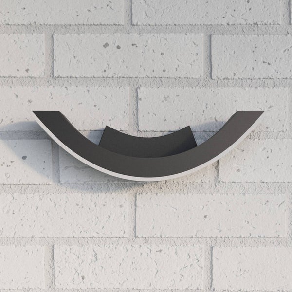 Gebogene LED-Außenwandleuchte aus Metall an einer hellen Backsteinwand.