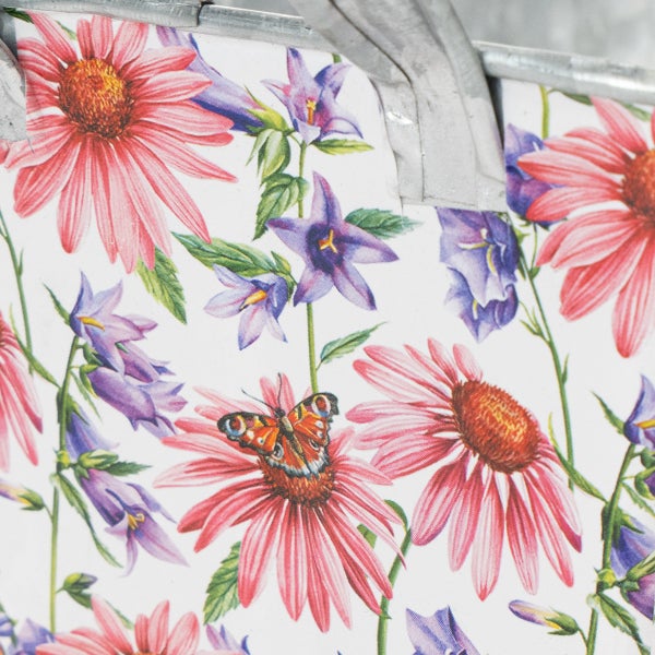 Detailansicht eines Metallkübels mit Blumenmuster aus Sonnenhut, Glockenblumen und einem Schmetterling.