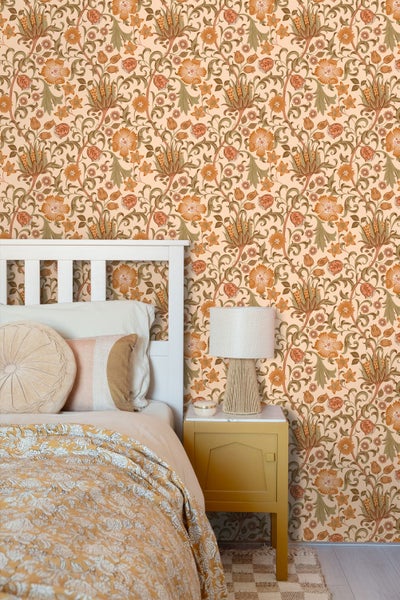 Vliestapete mit floralem Muster im Vintage-Stil in einem hellen Schlafzimmer mit weißem Bett und gelbem Nachttisch.