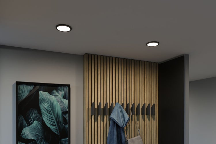 Zwei runde LED Einbaustrahler schwarz an der Decke in einem modern gestalteten Flur mit Holzlamellenwand und Kleiderhaken.
