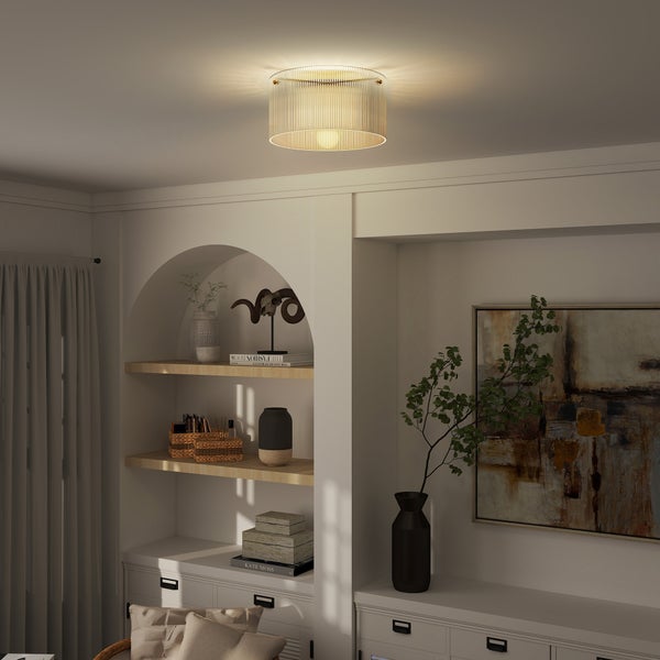 Moderne Deckenleuchte mit geriffeltem Glasschirm und Goldgestell in einem hellen Wohnzimmer mit Rundbogenregal und Wandkunst.
