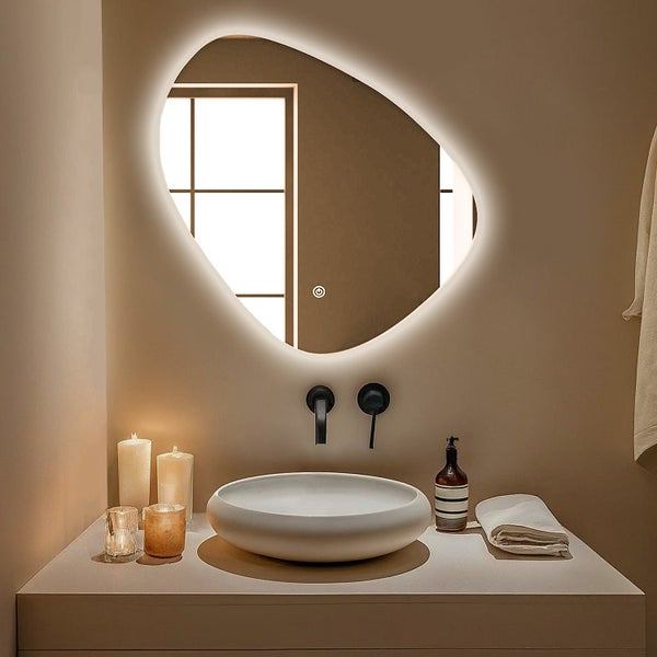 Organisch geformter Wandspiegel mit integrierter LED Beleuchtung und Touch Schalter über einem runden Aufsatzwaschbecken im modernen Badezimmer.