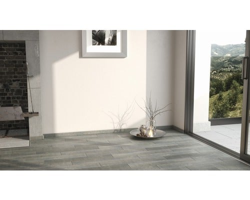 Heller Raum mit Steinfußboden, Kamin und Terrassentür