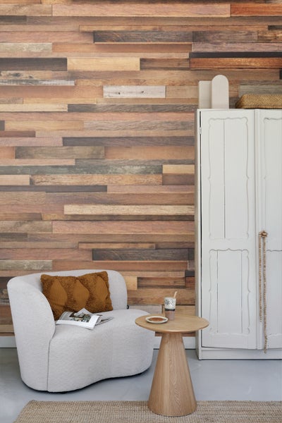 Wohnzimmer mit Sessel, Tisch und Holzwandverkleidung