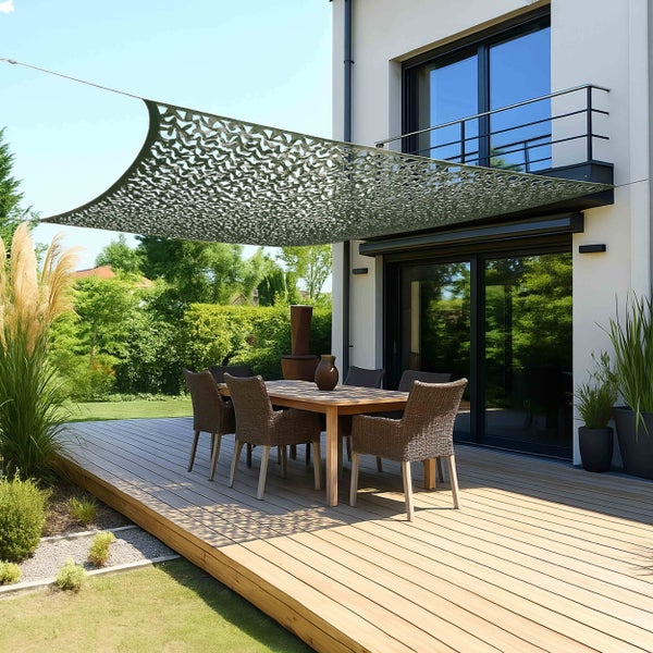 Moderne Terrasse mit Holzdeck und Gartenmöbeln unter einem Sonnensegel im Tarnnetz-Design.