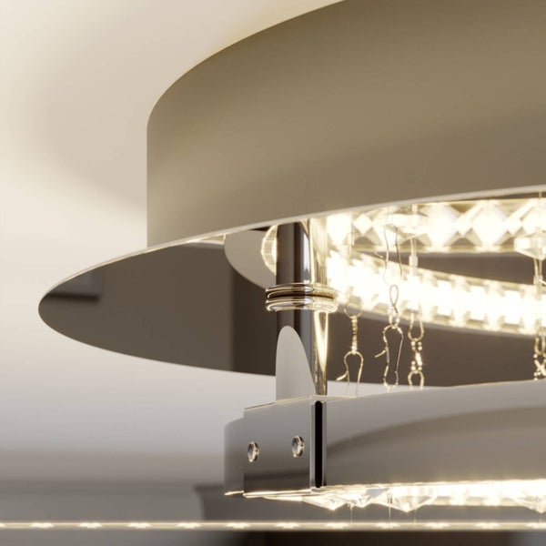 Nahaufnahme einer modernen Deckenleuchte mit Metallringen und lichtreflektierenden Kristallelementen.