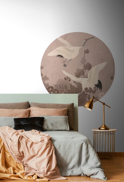 Schlafzimmer mit einer Wandtapete mit Kranichmotiv, einem Bett mit Kissen und einer Lampe auf einem Beistelltisch