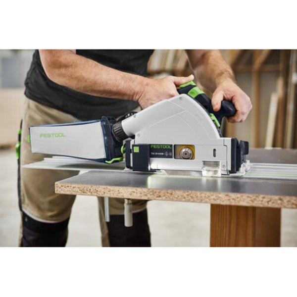 Person schneidet eine Platte mit einer Festool Tauchsäge auf einer Führungsschiene mit Staubsack.