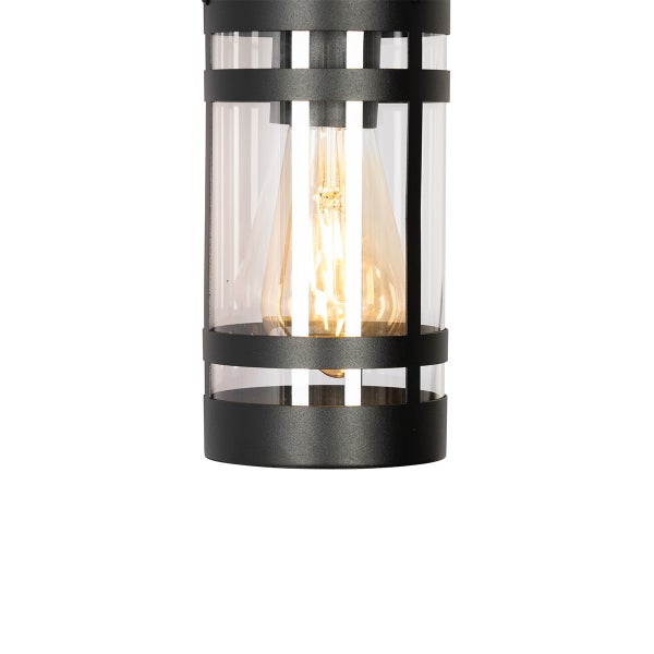 Außenwandleuchte mit zylindrischem Metallrahmen in Schwarz, klarem Glas und sichtbarem Filament-Leuchtmittel.