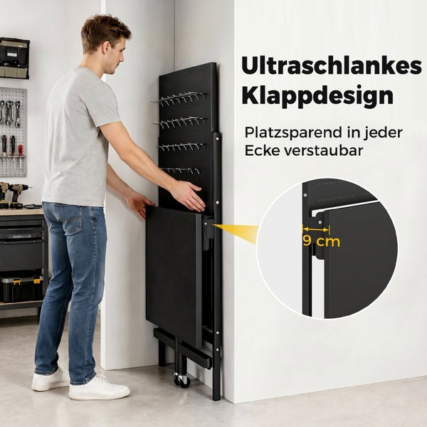 Ein Mann verstaut eine zusammengeklappte schwarze Werkbank mit Lochwand platzsparend an einer Wand. Tiefe zusammengeklappt 9 Zentimeter.