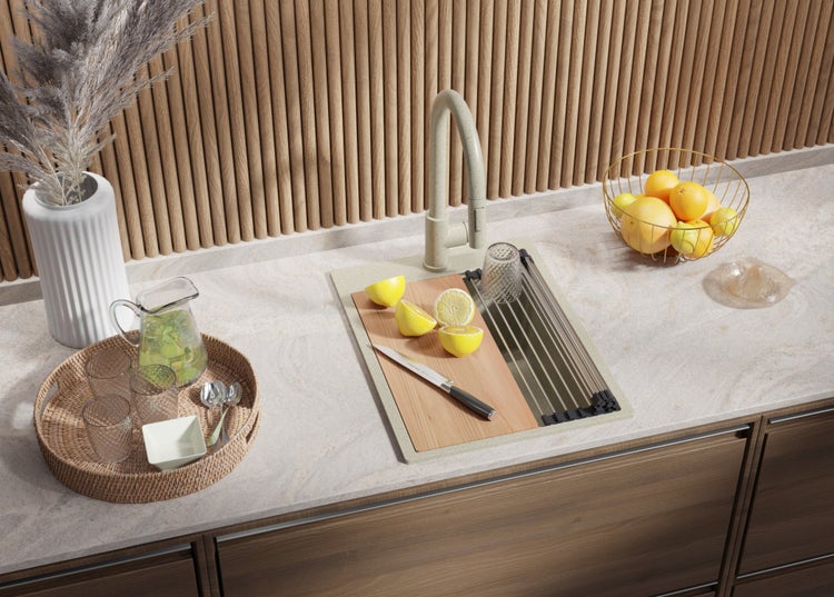 Küchenspüle mit Abtropffläche, Wasserhahn, Schneidebrett, Zitrone und Messer auf einer Küchentheke.