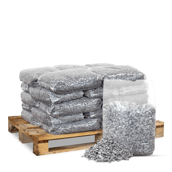 Säcke mit grauem Zierkies auf einer Holzpalette gestapelt, ein geöffneter Sack und loser Kies davor.