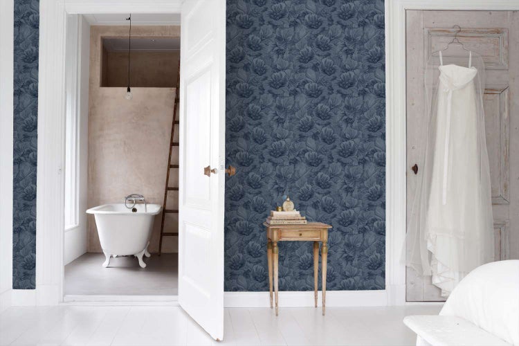 Wohnraum mit einer Wand tapeziert mit Vliestapete mit Blumenmuster. Im Hintergrund ein Badezimmer mit Badewanne.