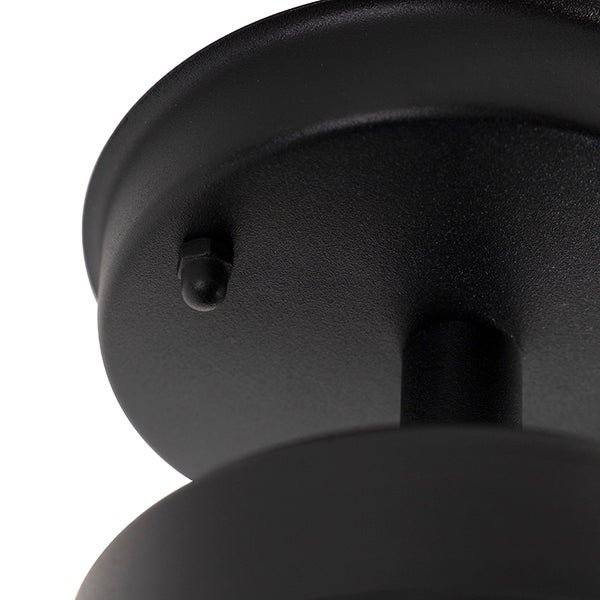 Detailaufnahme eines schwarzen Deckenbaldachins aus strukturiertem Metall für eine Leuchte mit einer Befestigungsschraube.