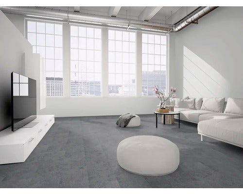 Geräumiges Wohnzimmer im Loftstil mit dunkelgrauem Boden in Steinoptik, großen Fenstern und moderner weißer Einrichtung.
