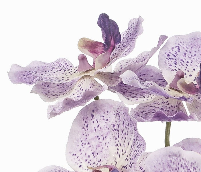 Künstlicher Blütenzweig aus Textilmaterial mit mehreren hellrosa Blüten an einem grünen Stiel.