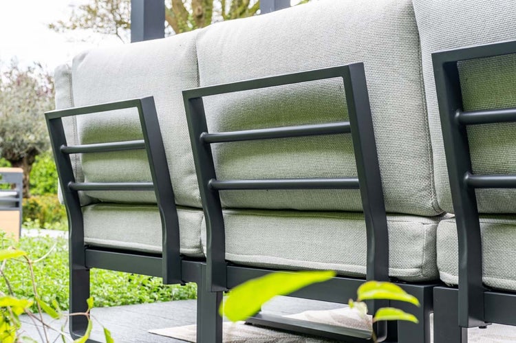 Detailansicht der Rückseite eines Garten-Loungesofas mit dunklem Metallrahmen und hellen Polsterkissen im Außenbereich.