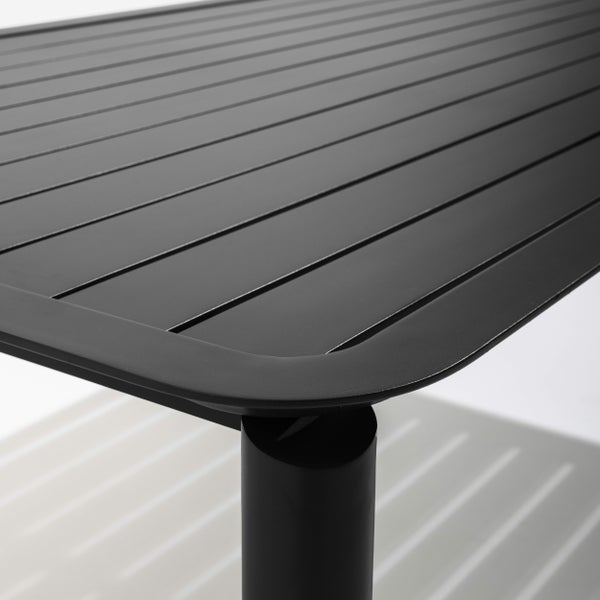 Nahaufnahme eines schwarzen Gartentischs aus Metall mit einer Tischplatte aus Lamellen und abgerundeten Ecken.