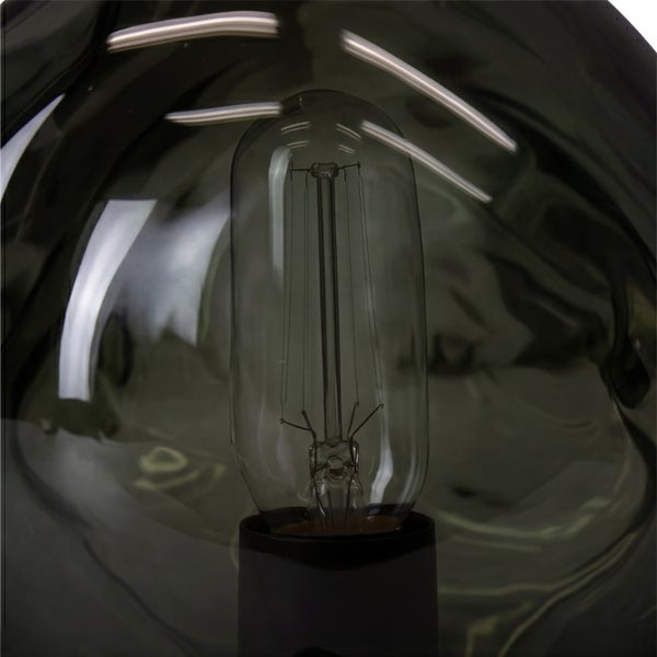 Nahaufnahme einer LED-Filament-Lampe in einer dunklen Glaskugel mit rauchiger Optik.