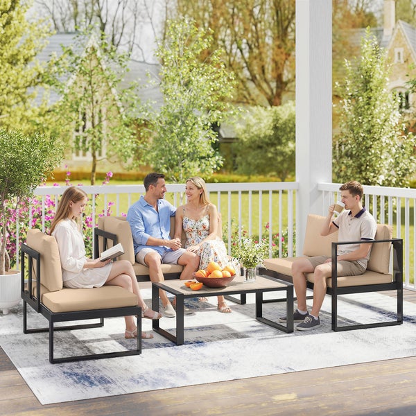 Modernes Garten-Lounge-Set aus schwarzem Metall mit beigen Polstern, bestehend aus Sofa, zwei Sesseln und Couchtisch auf einer hellen Terrasse.