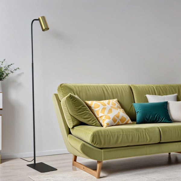 Einrichtungsszene mit einem grünen Sofa, Zierkissen und einer Stehlampe