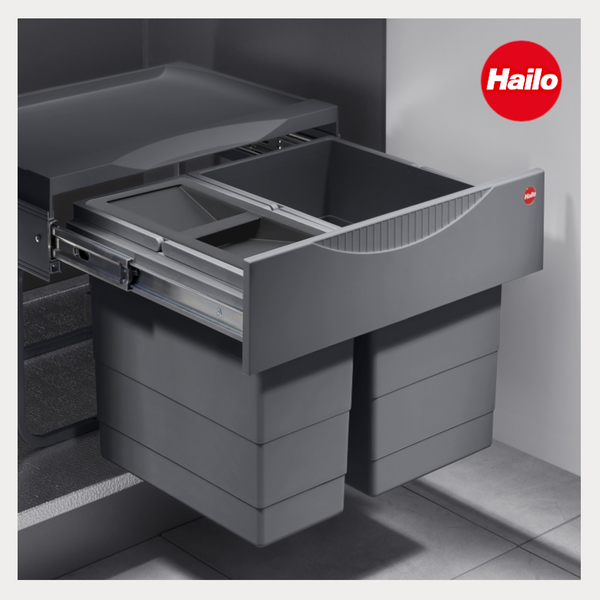 Ausziehbares Abfalltrennsystem von Hailo mit zwei Mülleimern und Ablagefläche, montiert auf Metallschienen im Küchenschrank. Hailo Logo.