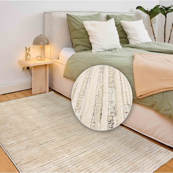 Beige Teppich mit linearem Muster in einem Schlafzimmerambiente