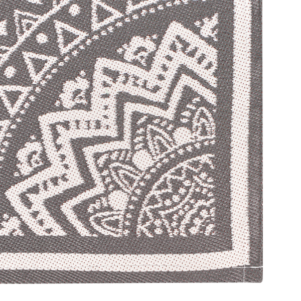 Detailansicht eines grau-weißen flachgewebten Teppichs mit geometrischem Muster aus Zickzacklinien und Dreiecken.