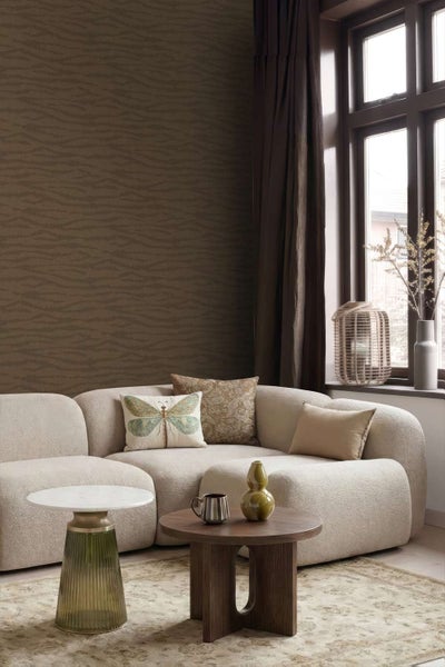 Wohnzimmer mit strukturierter Vliestapete, modernem cremefarbenem Sofa, Beistelltischen und Fenster mit Vorhang.