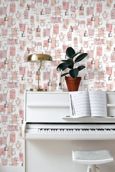 Dekorative Tapete mit Parfümflakon-Muster hinter einem weißen Klavier.