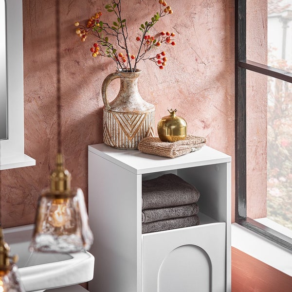 Badezimmeransicht mit weißem Waschbeckenunterschrank, Handtüchern und Dekoration