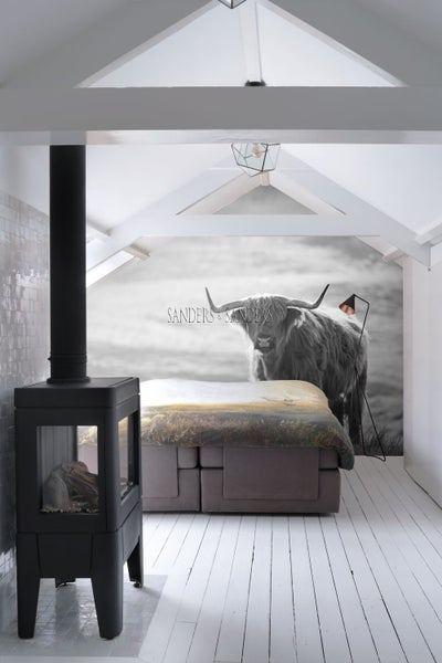 Schlafzimmer mit Boxspringbett, Kaminofen und Fototapete