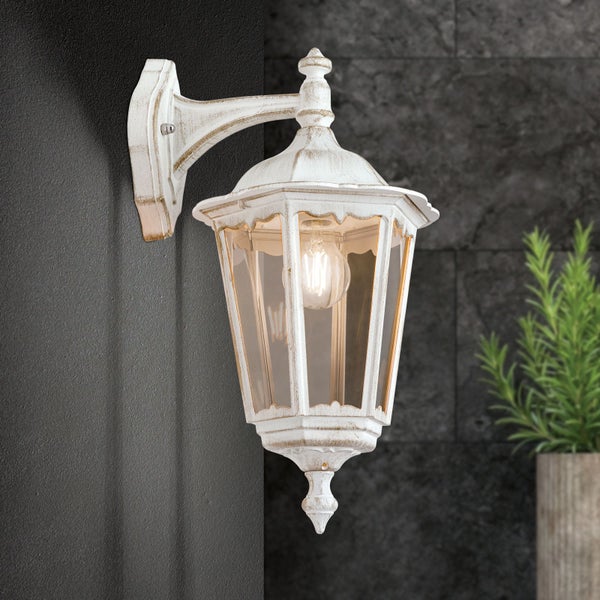 Klassische Außenwandleuchte im Vintage-Stil mit klarem Glas und Patina-Effekt, an einer Wand montiert.