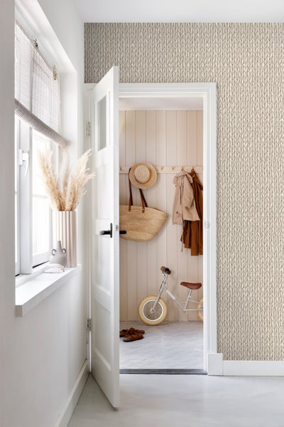 Helles Zimmer mit Stricktapete, geöffneter Tür und dekorativen Elementen