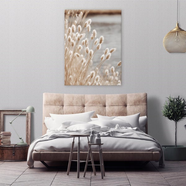 Ein modernes Schlafzimmer mit einem gepolsterten Bett, einem Wandbild mit Hasenschwanzgras und dekorativen Accessoires in einer ruhigen Atmosphäre.