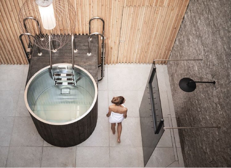 Modernes Spa mit rundem Tauchbecken aus Holz und Edelstahl, Walk-In-Dusche, Steinwand und Wandverkleidung aus Holzlamellen.