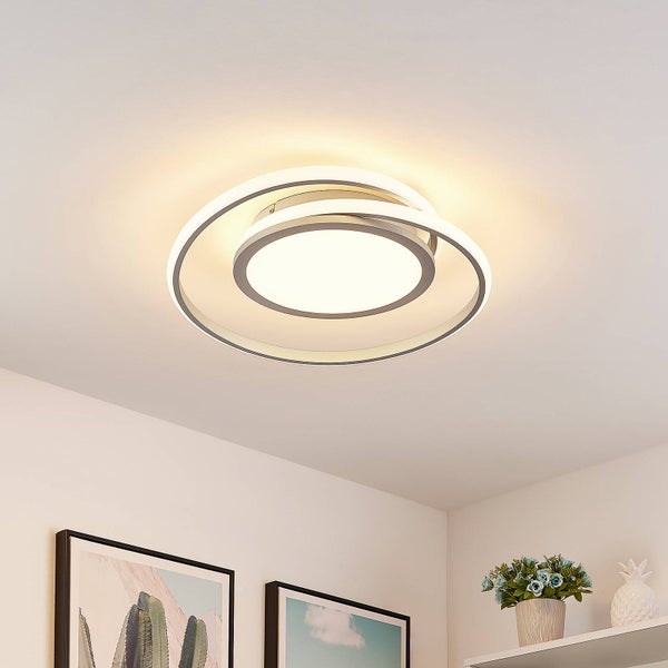 Moderne LED-Deckenleuchte mit konzentrischen Ringen in einem hellen Raum, montiert an einer weißen Decke.