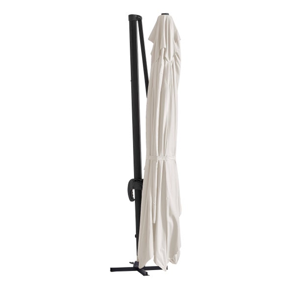 Moderner Außenbereich mit großem Ampelschirm, Wicker-Sofa, Sessel, Holz-Couchtisch und Topfpflanzen auf einer hellen Steinterrasse.