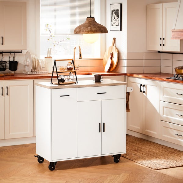 Helle Küche mit Küchenwagen, Spüle und Kochfeld.