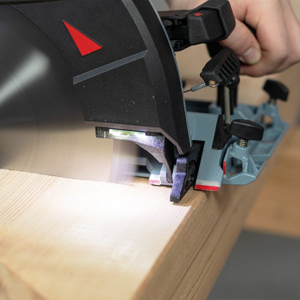 Eine Handkreissäge mit LED Beleuchtung sägt ein Stück Holz.