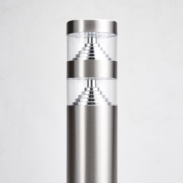 Moderne Außenleuchte aus Edelstahl in Zylinderform mit zwei transparenten Diffusoren und stufenförmigen Reflektoren.