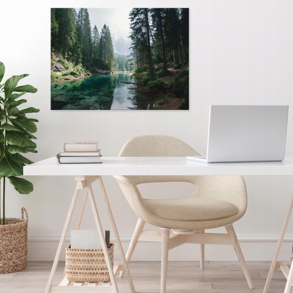Großes Wandbild mit Wald- und Seelandschaft über einem hellen, minimalistischen Schreibtisch mit Laptop, Stuhl und Zimmerpflanze.