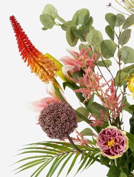 Nahaufnahme eines Monstera-Zweigs mit grünen Blättern, charakteristischen Löchern und Luftwurzeln.