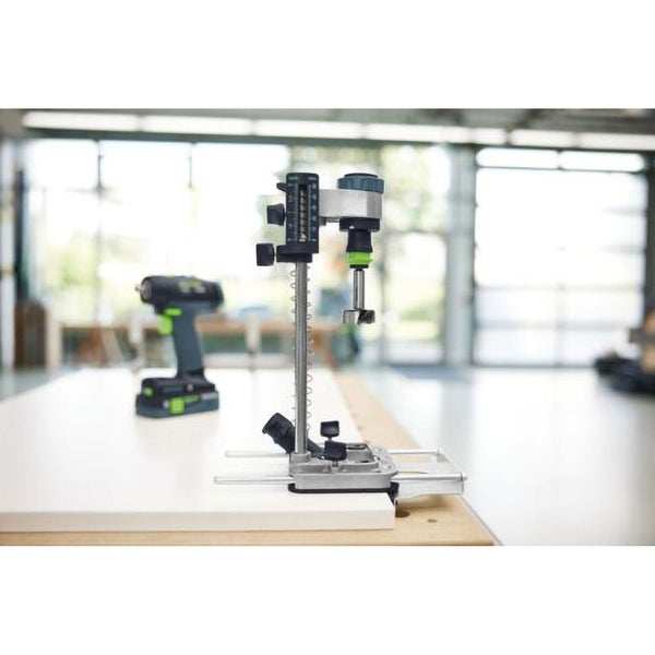 Bohrmaschine mit Dübelbohrvorrichtung auf einer Werkbank