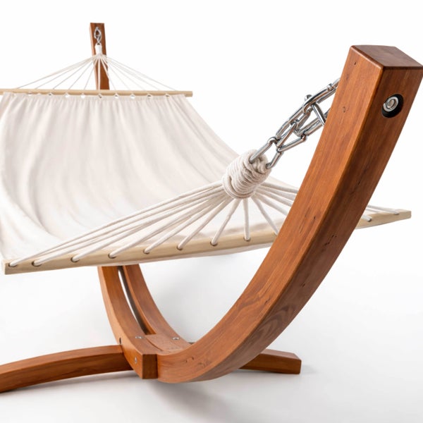 Stabhängematte mit gebogenem Holzgestell und weißem Stoff.