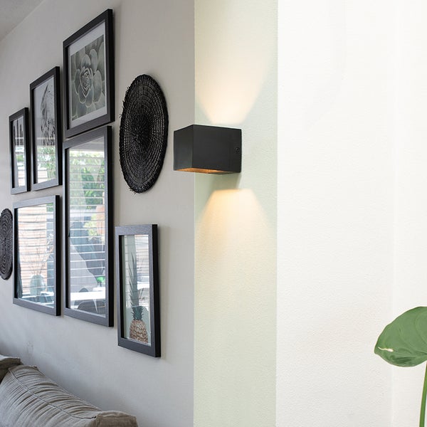 Wohnraum mit Wandleuchte, Dekorationen und Bilderrahmen an der Wand